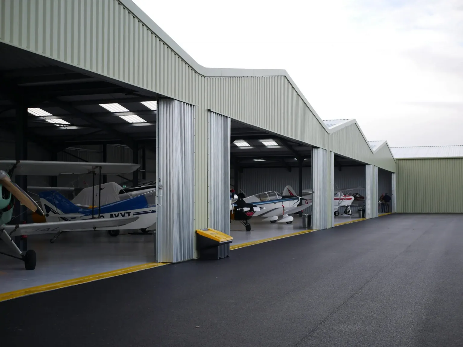 Steel Framed Aircraft Hangars with multiple planes and large folding hangar doors