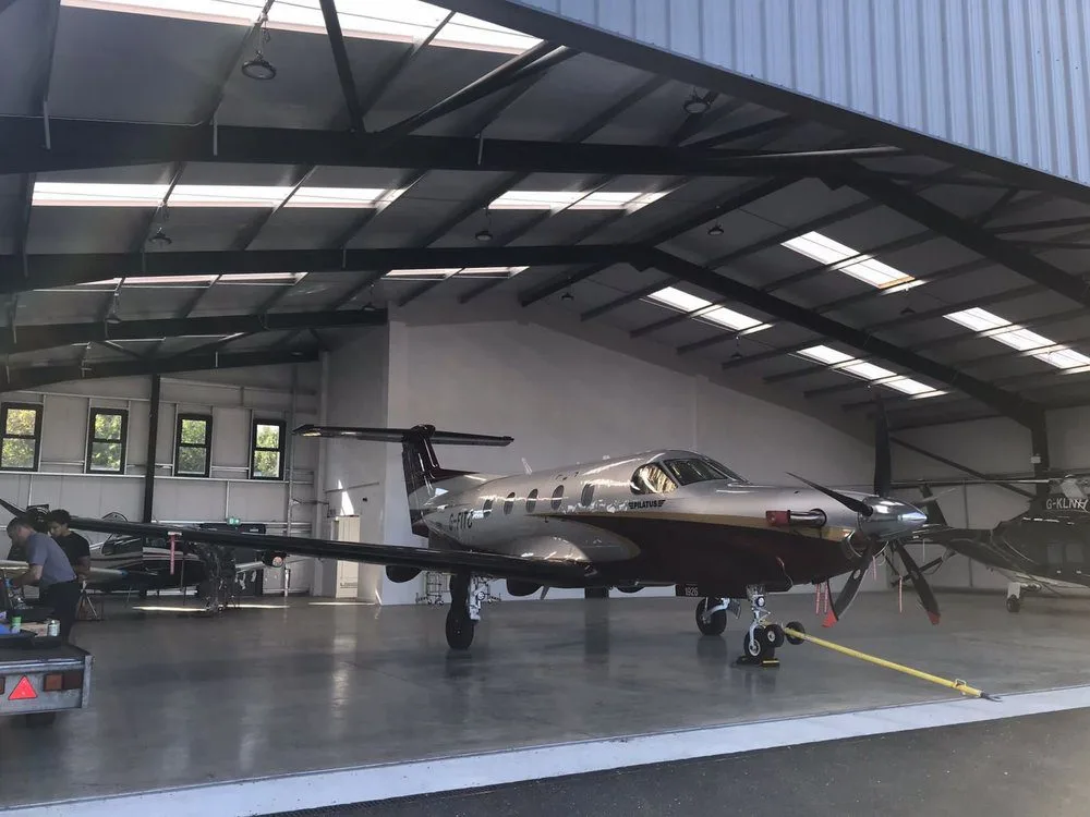 Inside a Steel Aircraft and Helicopter Hangar with private plane inside in the UK