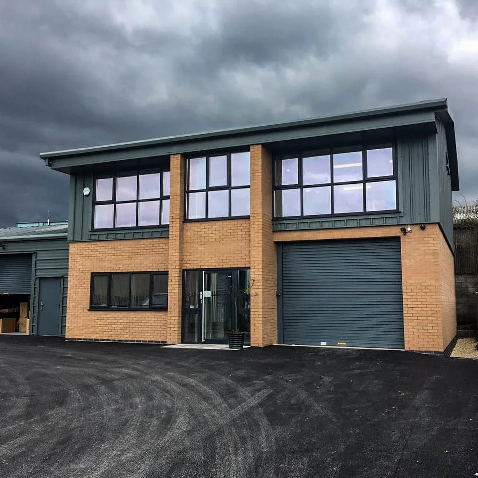 A Commercial Steel Framed Building with mezzanine floor, detail brickwork, storage workshop, full height curtain walling glazing installed in Cheshire by Springfield Steel Buildings. The building will be used as offices with a workshop and industrial storage extension.